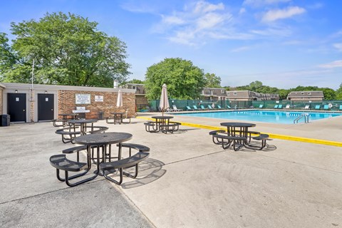 Picnic tables are arranged around a pool.