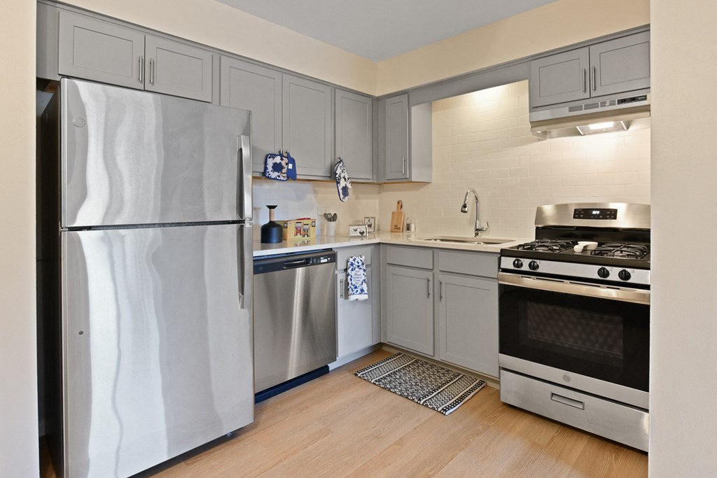 a kitchen with stainless steel appliances and white cabinets a kitchen with stainless steel appliances and white cabinets at Aspen Ridge Apartments, West Chicago, Illinois