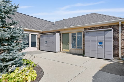 the front entrance of a brick house with two garage doors at Aspen Ridge Apartments, West Chicago