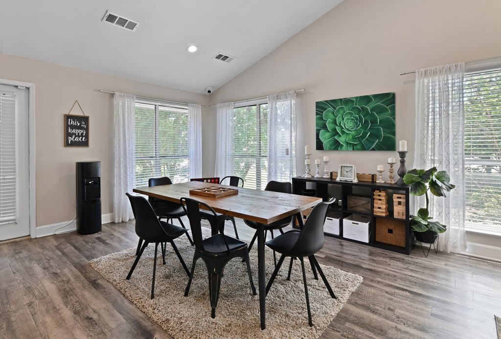 a dining room with a wooden table and black chairs at 300 Riverside Apartments, Austell, 30168