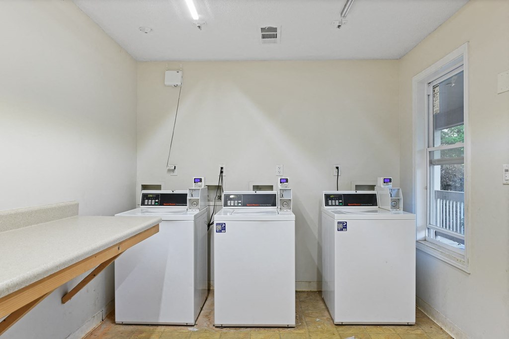 a laundry room with three washers and dryers at Waldan Pond Apartments, Acworth, Georgia