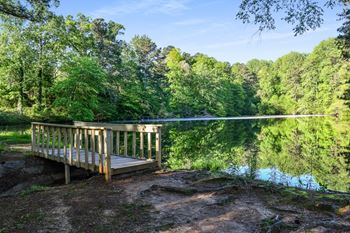 a dock on a lake with trees in the background at Premier Apartments, Georgia