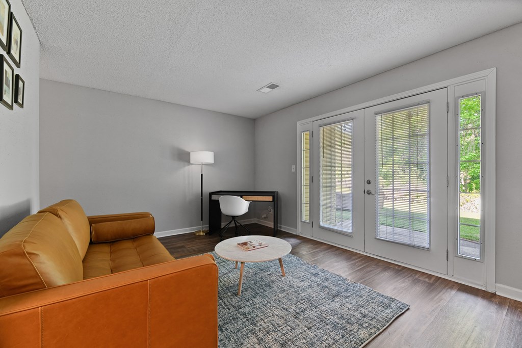 a living room with a couch coffee table and french doors at Premier Apartments, Austell