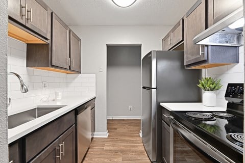 a kitchen with dark cabinets and white countertops at Premier Apartments, Austell, 30168