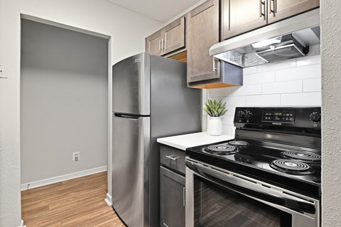 a kitchen with stainless steel appliances and a wooden floor