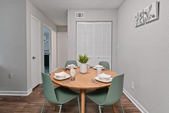 a dining area with a wooden table and green chairs
