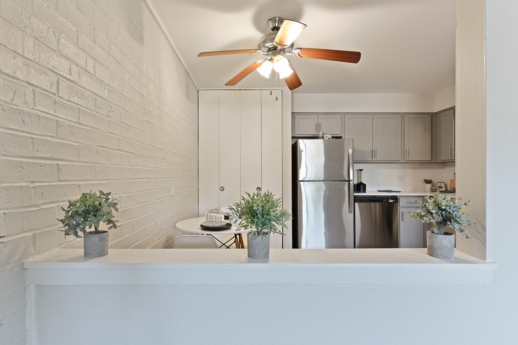 Newly renovated kitchen and dining room with white cabinets, stainless steel appliance, and a ceiling fan  at Aspen Ridge Apartments in West Chicago Illinois 60185