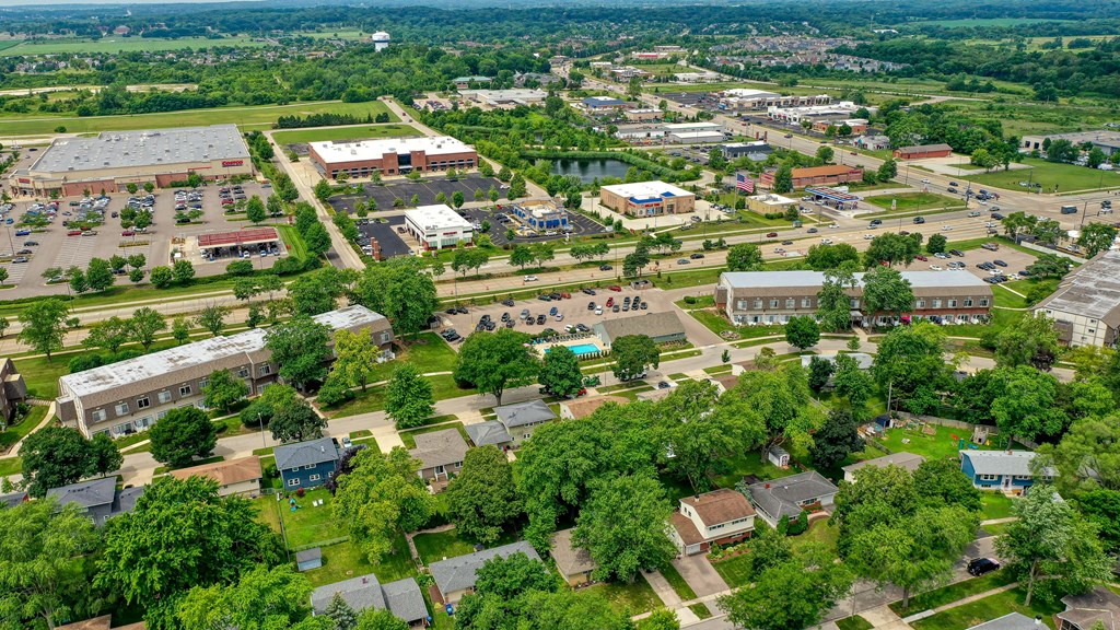 An aerial view of a town with buildings, roads, and trees.