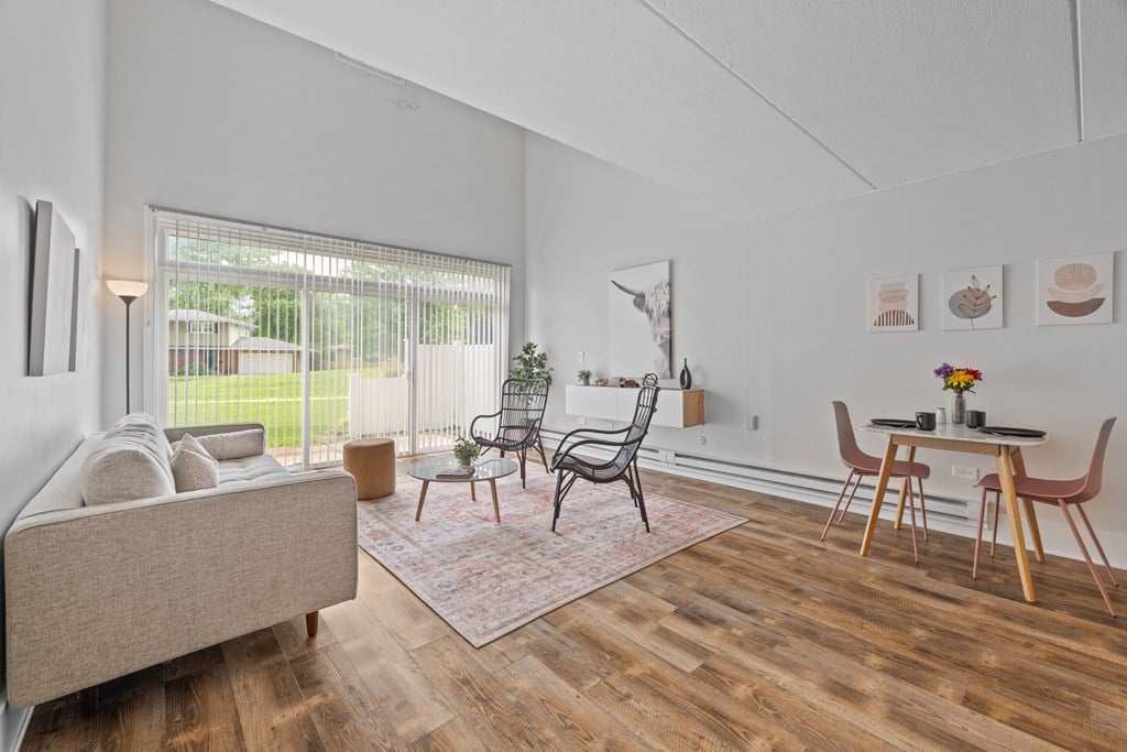 A living room with a sofa, chairs, and a table.