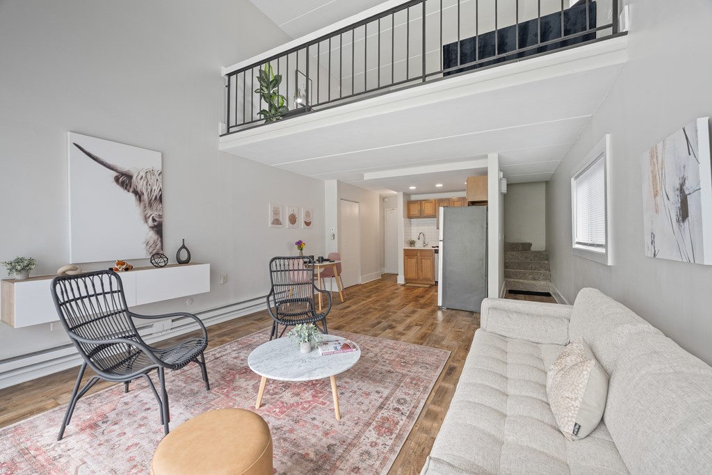 A living room with a white couch, a coffee table, and a chair.