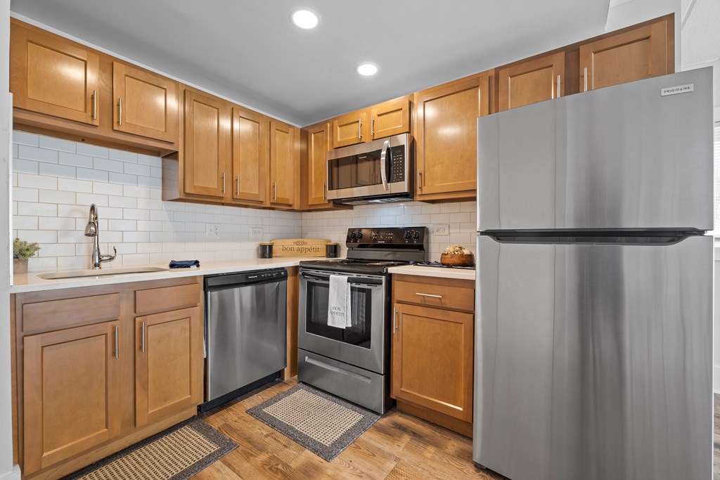 A modern kitchen with wooden cabinets and stainless steel appliances.