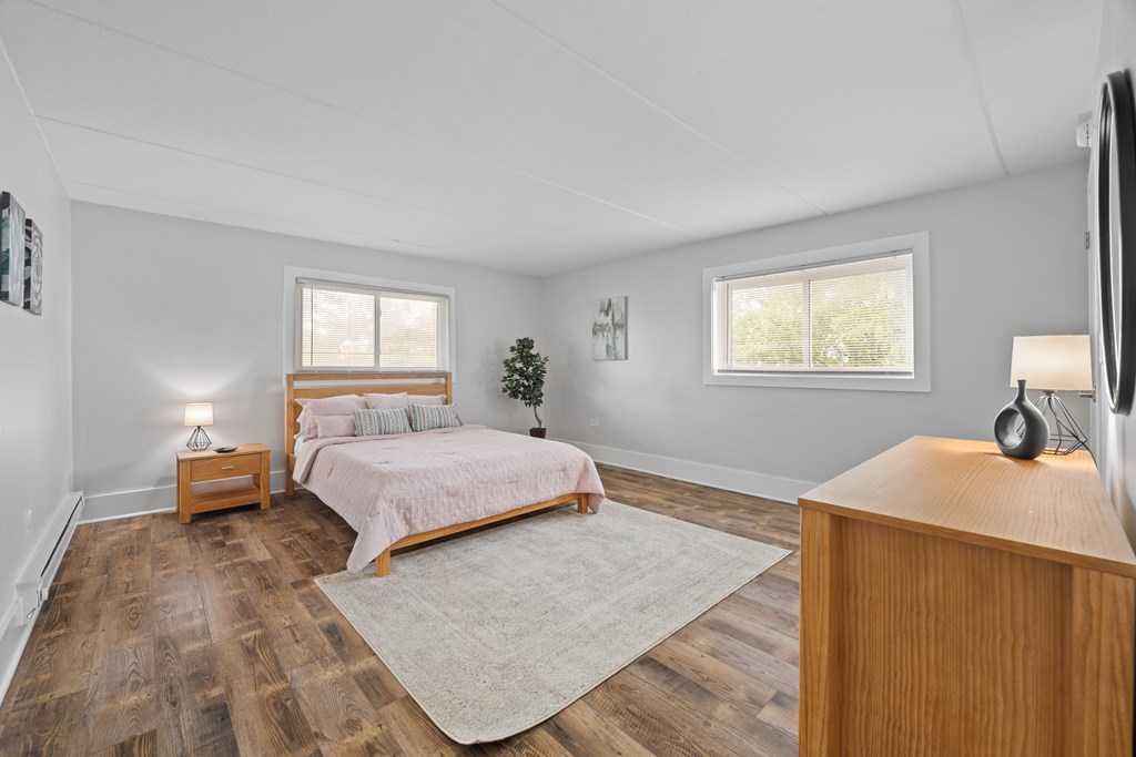 A bedroom with a bed, nightstand, and a television.