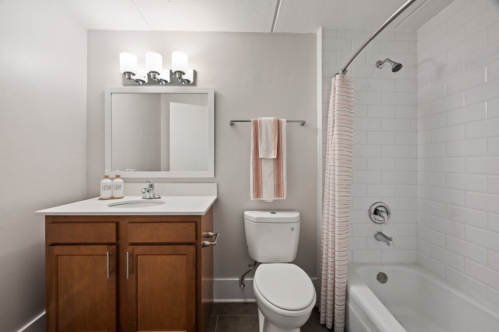 A white bathroom with a toilet, sink, and shower.