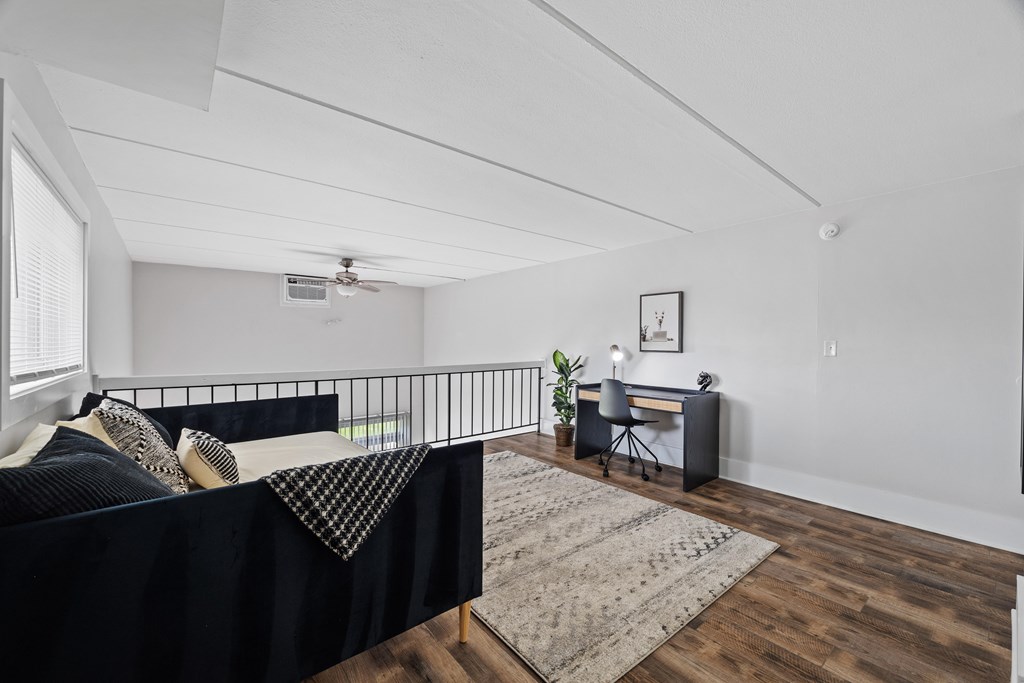 A bedroom with a bed, desk, and chair.