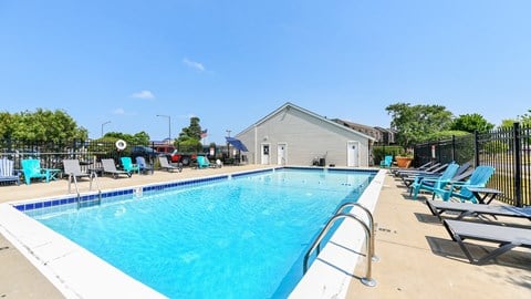 A large pool with crystal clear water and comfortable lounge seats at Fox Run Apartments in St Charles IL 60174