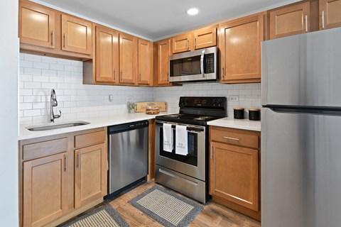 a kitchen with wooden cabinets and stainless steel appliances at Fox Run Apartments, St. Charles, IL, 60174