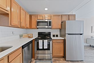 a kitchen with wood cabinets and stainless steel appliances