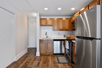Renovated kitchen with new stainless steel appliances, large sink, white countertops and bright lights at Fox Run Apartments in St Charles IL 60174
