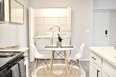 a kitchen with a table and chairs and a washer and dryer - Photo Gallery 4