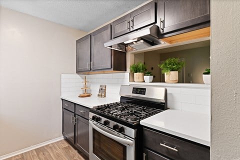 a kitchen with black cabinets and white countertops at 300 Riverside Apartments, Austell, 30168