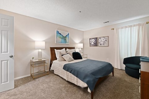 a bedroom with a bed and a chair in a room at 300 Riverside Apartments, Austell, GA, 30168