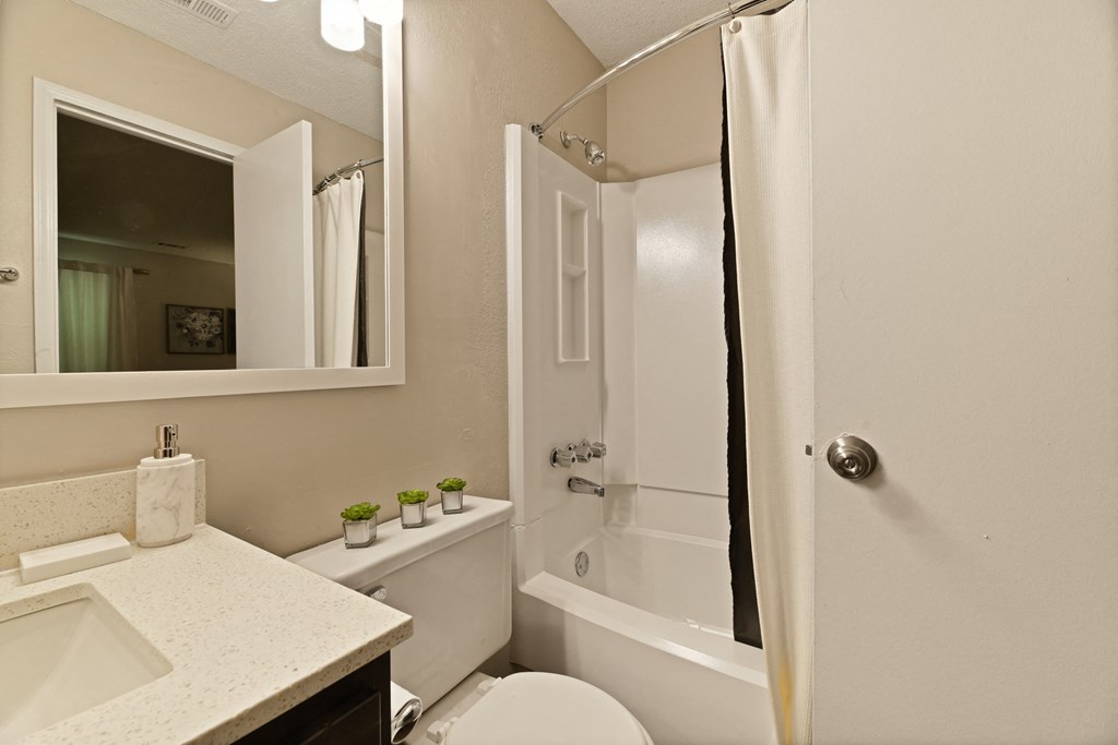 a bathroom with a white toilet next to a white bathtub at 300 Riverside Apartments, Georgia, 30168