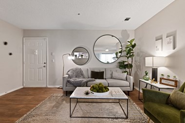 a living room with a couch coffee table and two mirrors - Photo Gallery 4