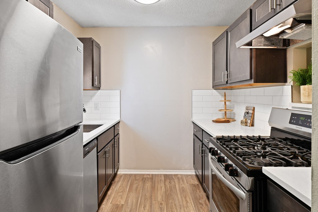 a kitchen with white countertops and black and stainless steel appliances at 300 Riverside Apartments, Austell, GA
