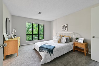 a bedroom with a bed and a dresser - Photo Gallery 2