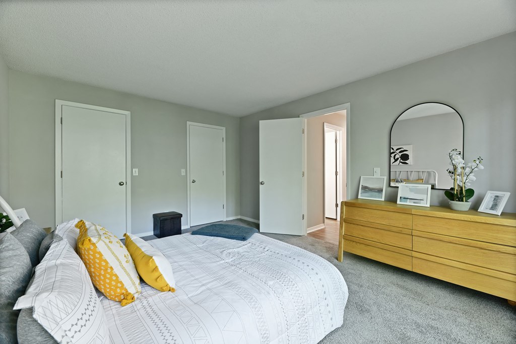 a bedroom with a large bed and a dresser with a mirror at Waldan Pond Apartments, Acworth, GA, 30102
