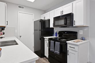 Updated kitchen with white cabinets and black appliances at Trinity Lakes Apartments in Columbus Ohio 43228 - Photo Gallery 2