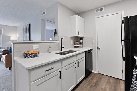 Newly renovated kitchen with white cabinets, black appliances and white countertops at Trinity Lakes Apartments in Columbus Ohio 43228