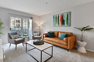 A spacious living room with patio and large windows for natural light at Trinity Lakes Apartments in Columbus Ohio 43228