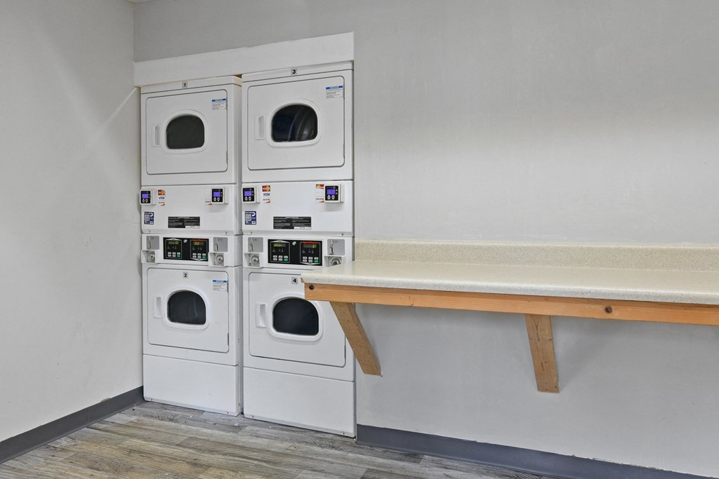 a laundry room with washing machines and a bench