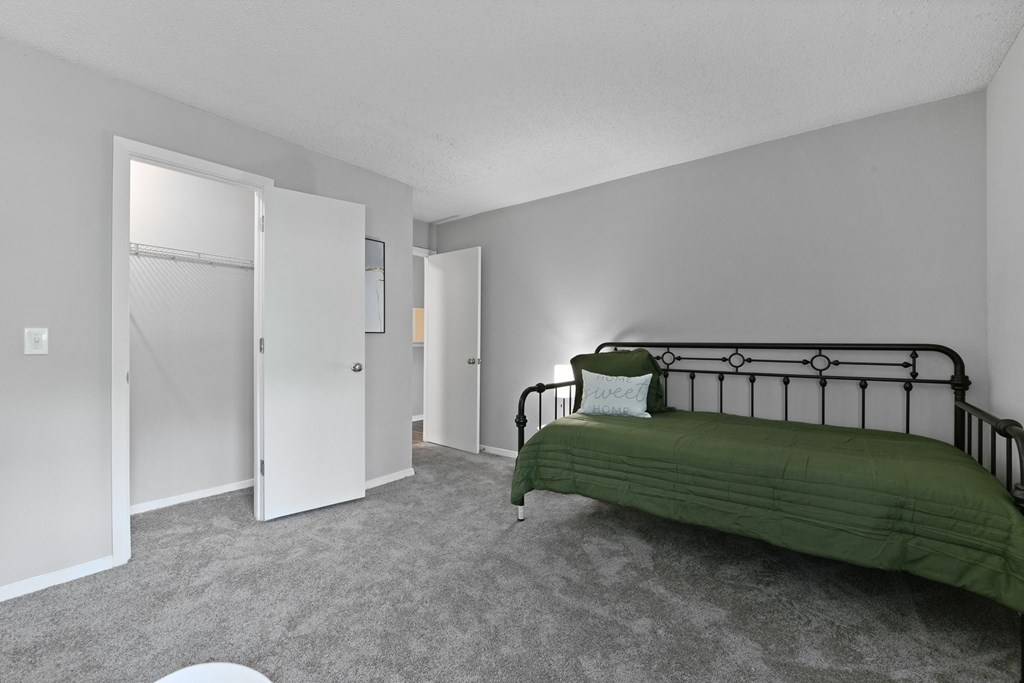 an empty bedroom with a bed and a closet