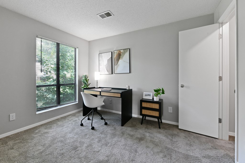 an office with a large window and a desk with a chair