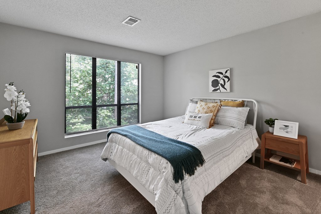 a bedroom with a bed and a large window