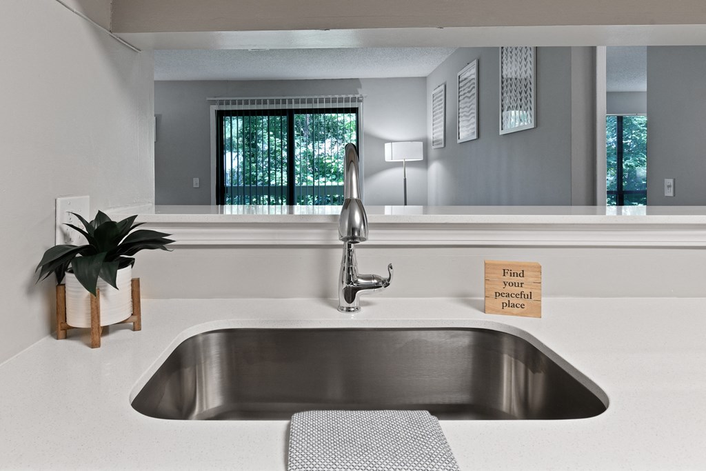 a large stainless steel sink in a white kitchen