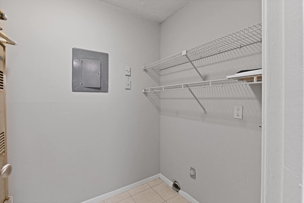 a white room with a white closet and a white shelf on the wall