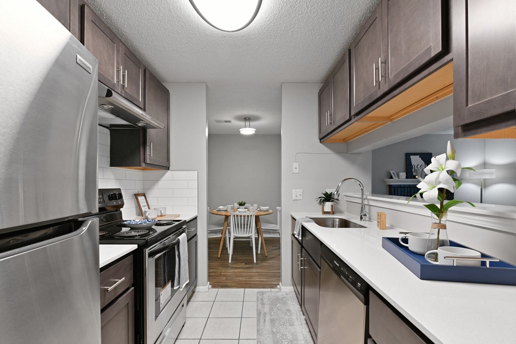 an open kitchen with stainless steel appliances and a dining room with a table