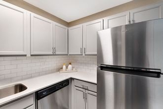 Newly updated kitchen with stainless steel appliances, white subway tile, and white cabinets for a clean and bright look at The Ponds of Naperville, Illinois, 60565 - Photo Gallery 3