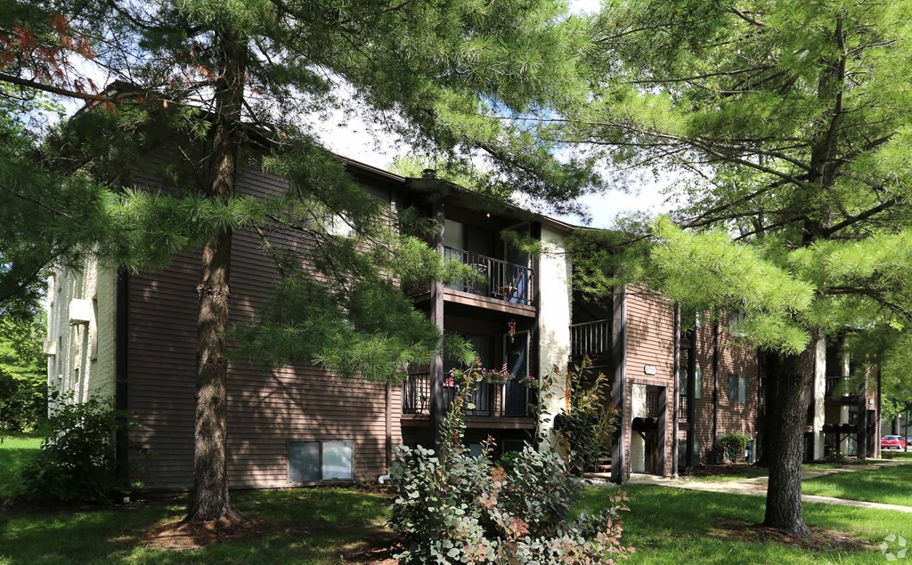 the front of our building with trees and grass