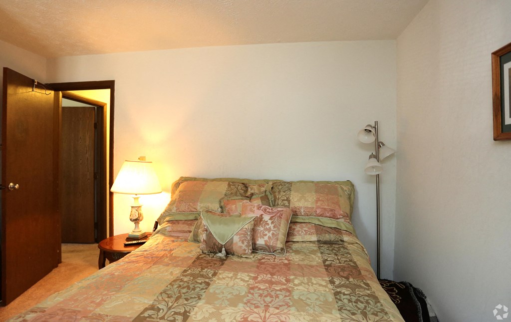 a bedroom with a bed and a door to a bathroom