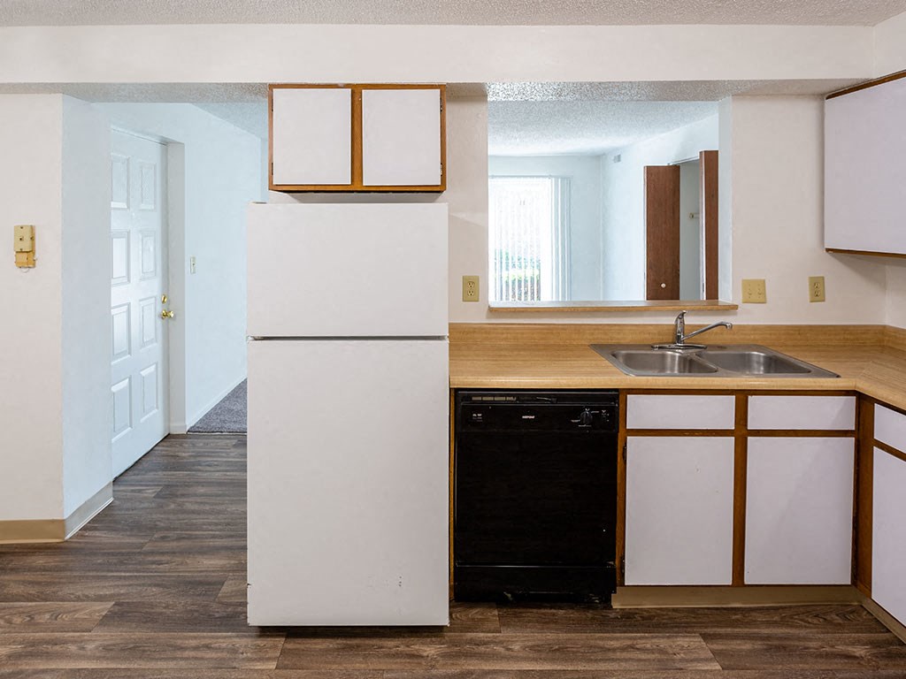 an empty kitchen with a sink and a refrigerator