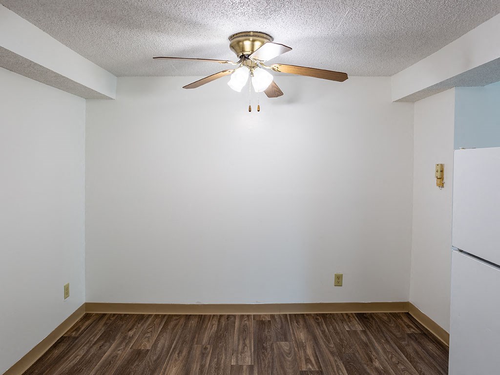 a room with a ceiling fan and a refrigerator