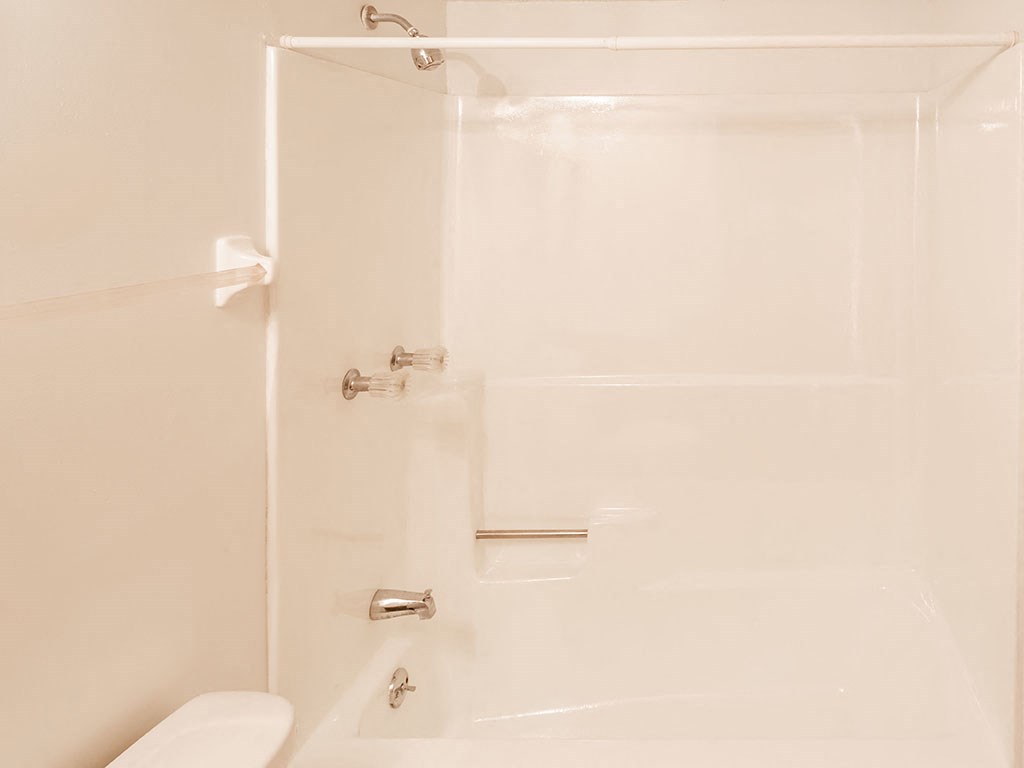 a white bathroom with a shower and a toilet