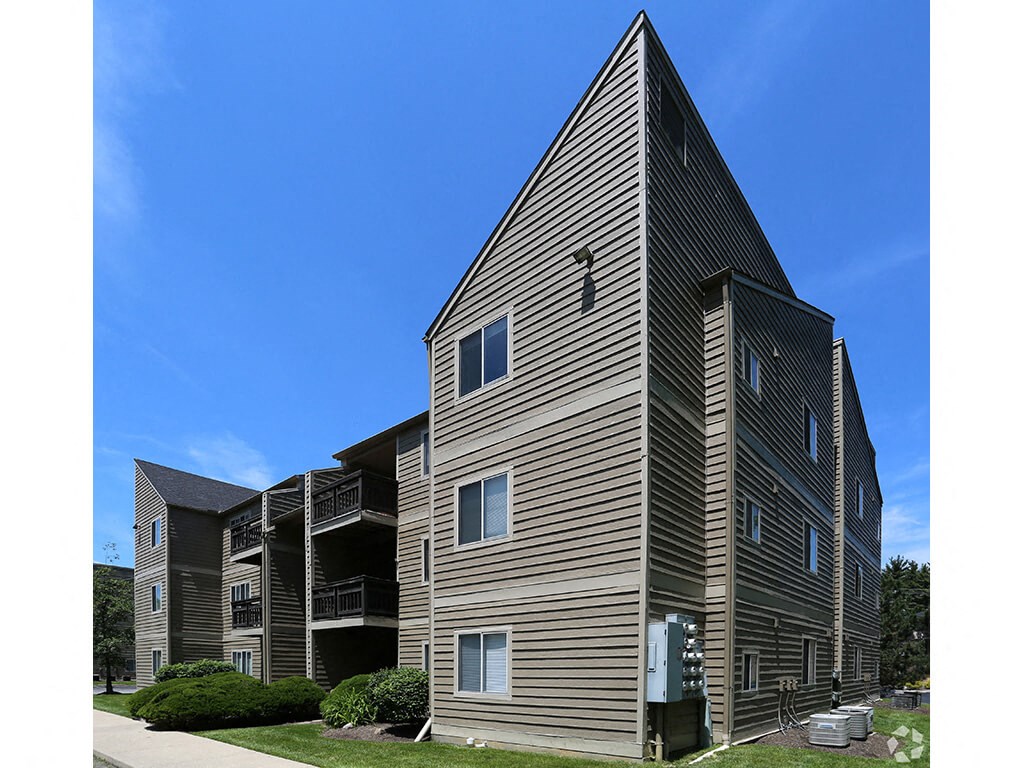 a tall apartment building with wood siding