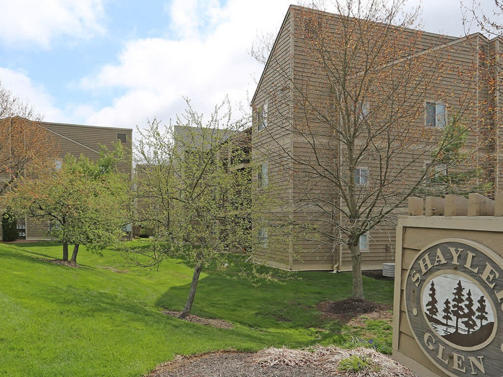 a sign in front of a building on a green lawn