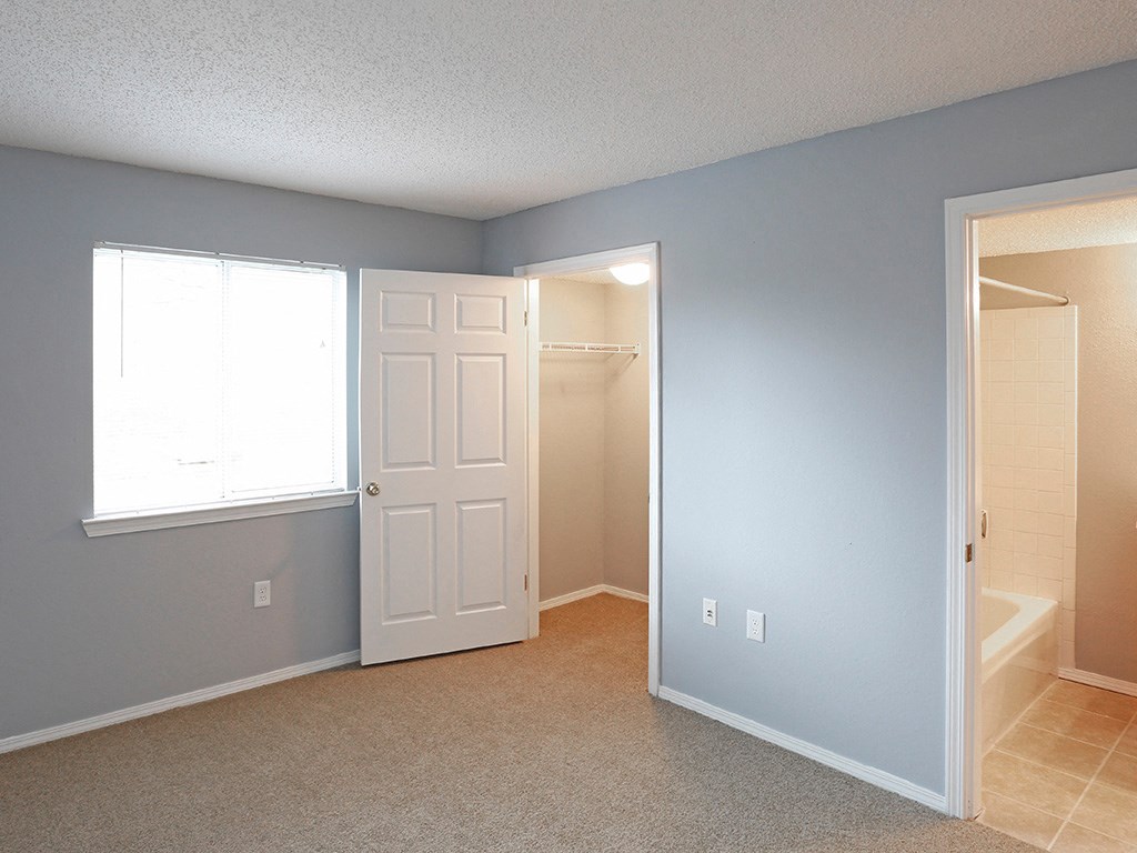 an empty room with a bathroom and a closet