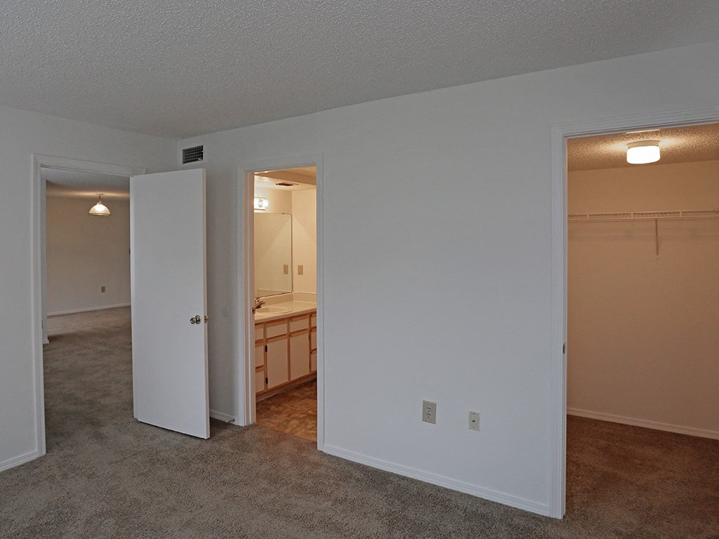 an empty living room with an open door to a bathroom